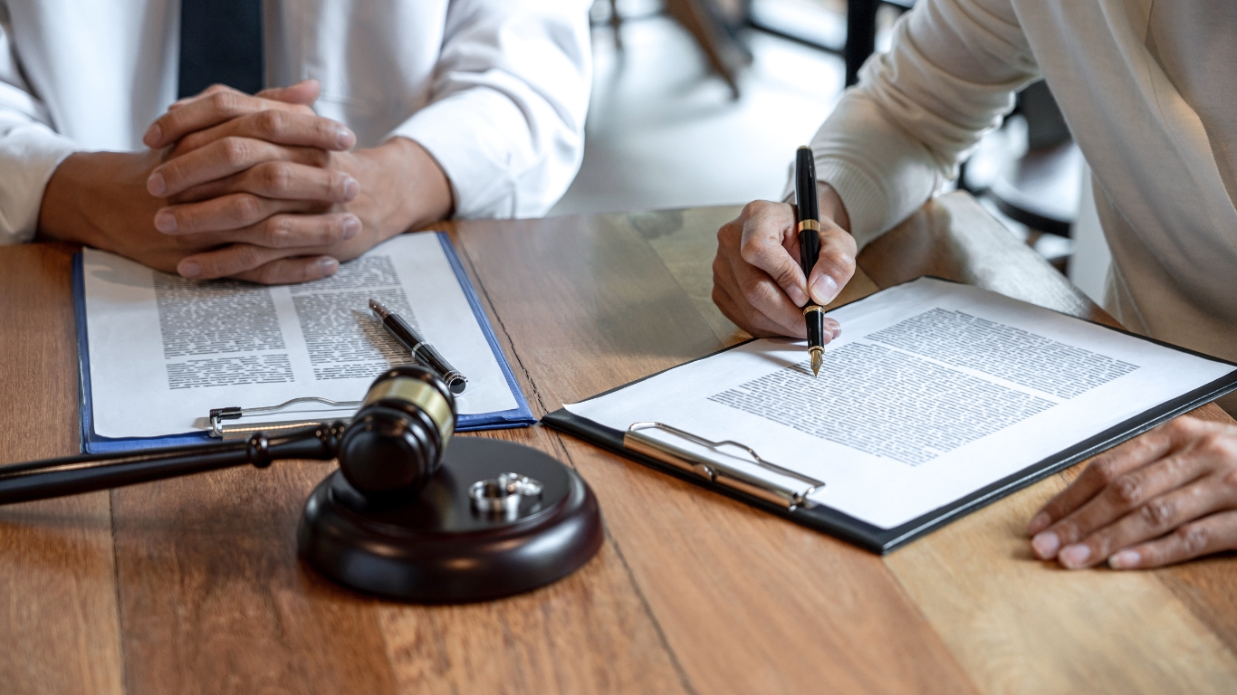 Luật sư ký kết hợp đồng dịch vụ ly hôn với khách hàng.